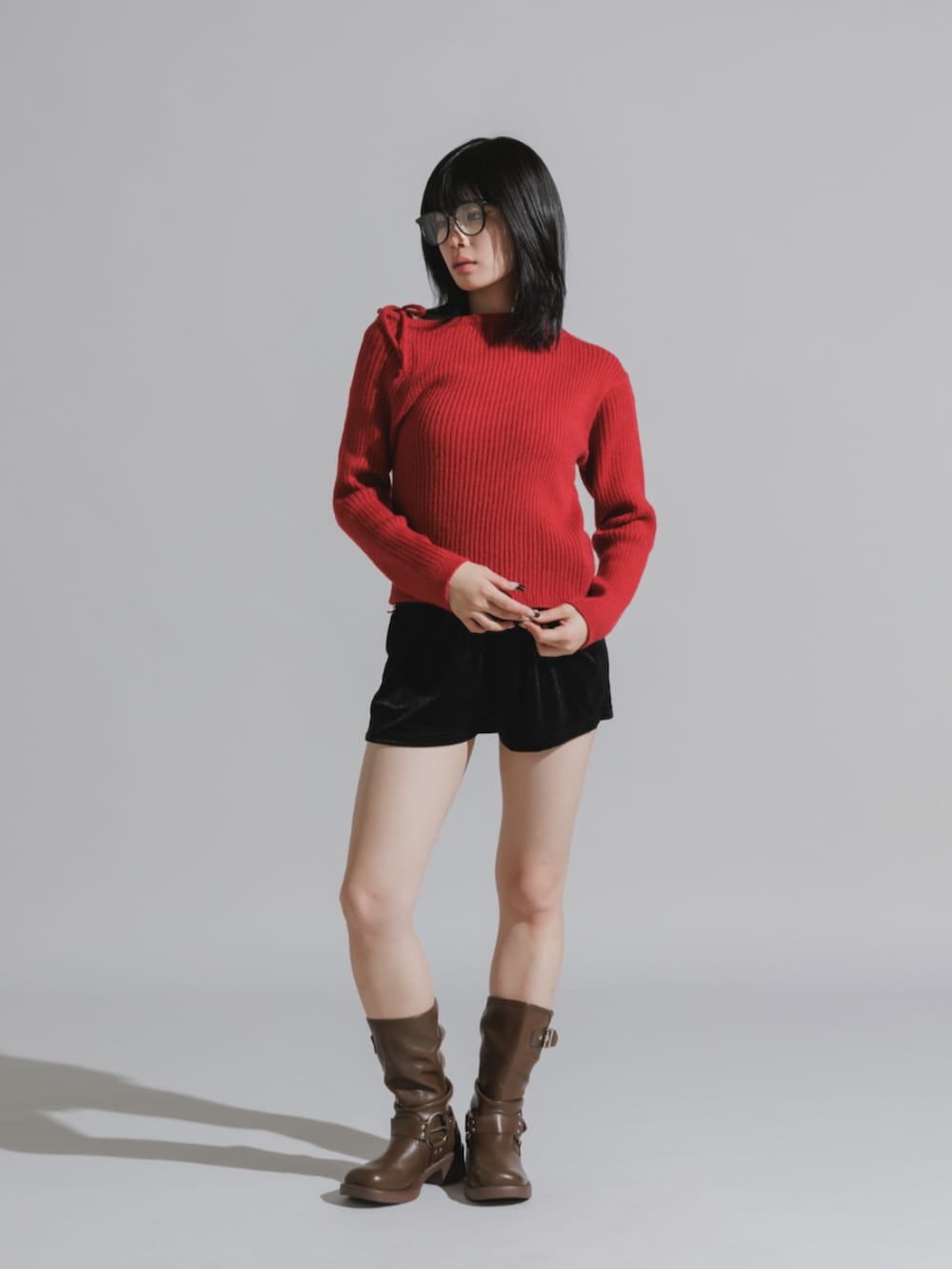 ブラック系のその他パンツ、ブラウン系のブーツ、レッド系のニット/セーターを着用したレディースの秋コーディネートの2枚目の写真