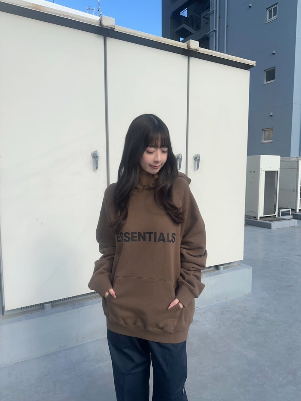 ブラウン系のパーカー、ブルー系のチノパンツを着用したレディースの春コーディネートの2枚目の写真