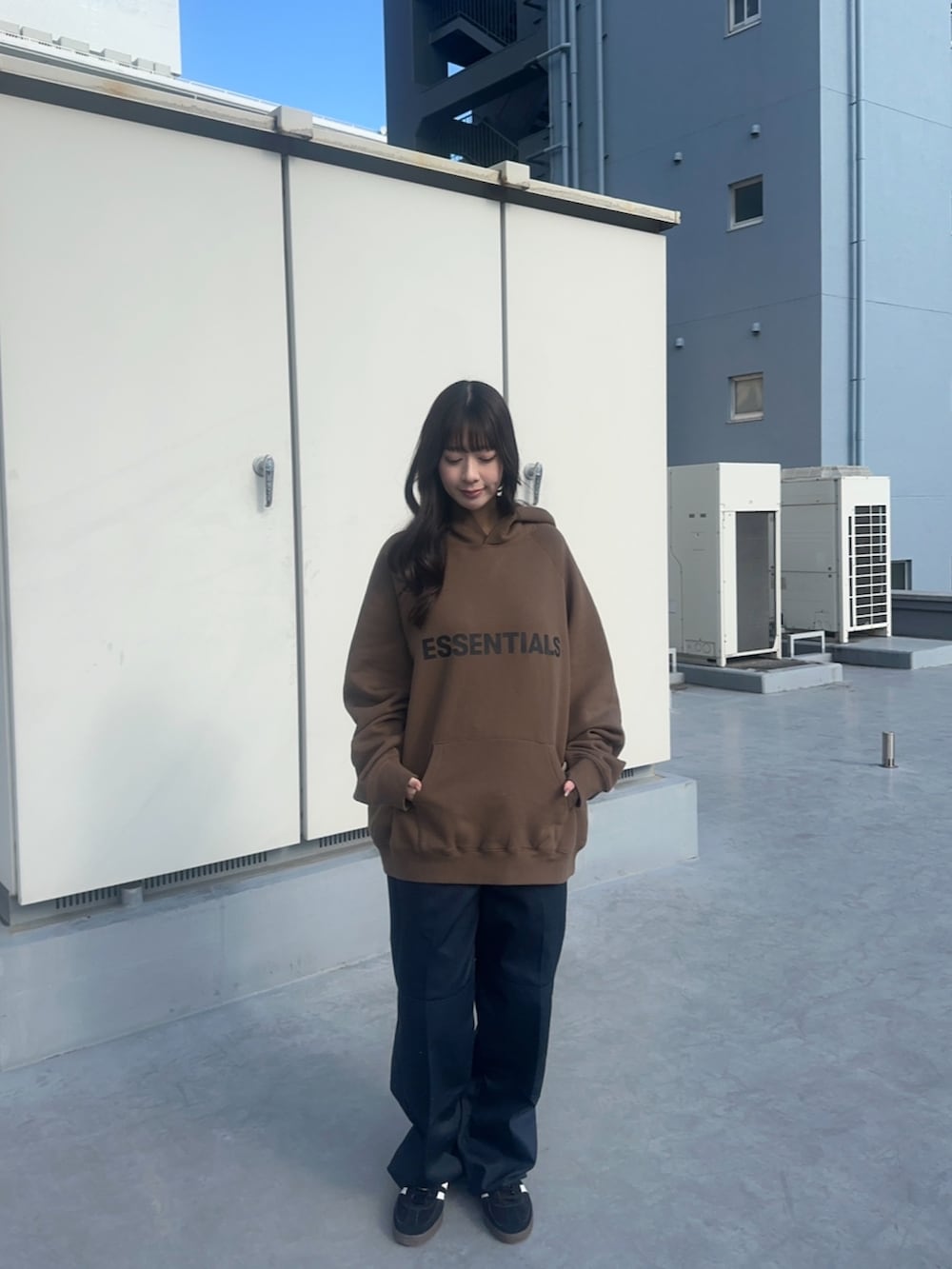 ブルー系のチノパンツ、ブラウン系のパーカーを着用したレディースの春コーディネートの2枚目の写真