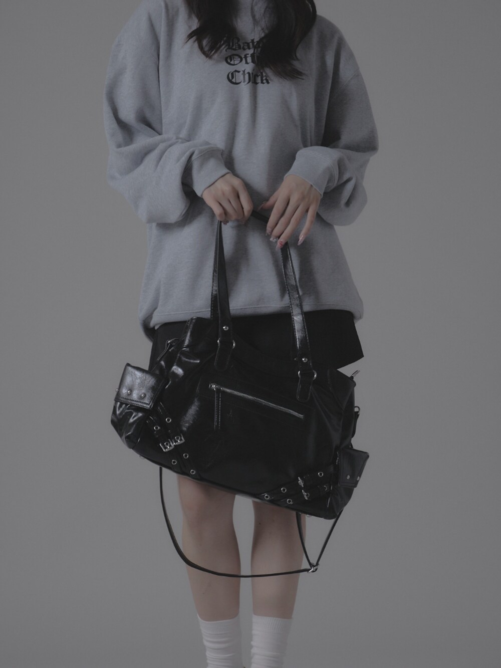 グレー系のスウェット、ブラック系のショルダーバッグを着用したレディースの秋コーディネートの3枚目の写真