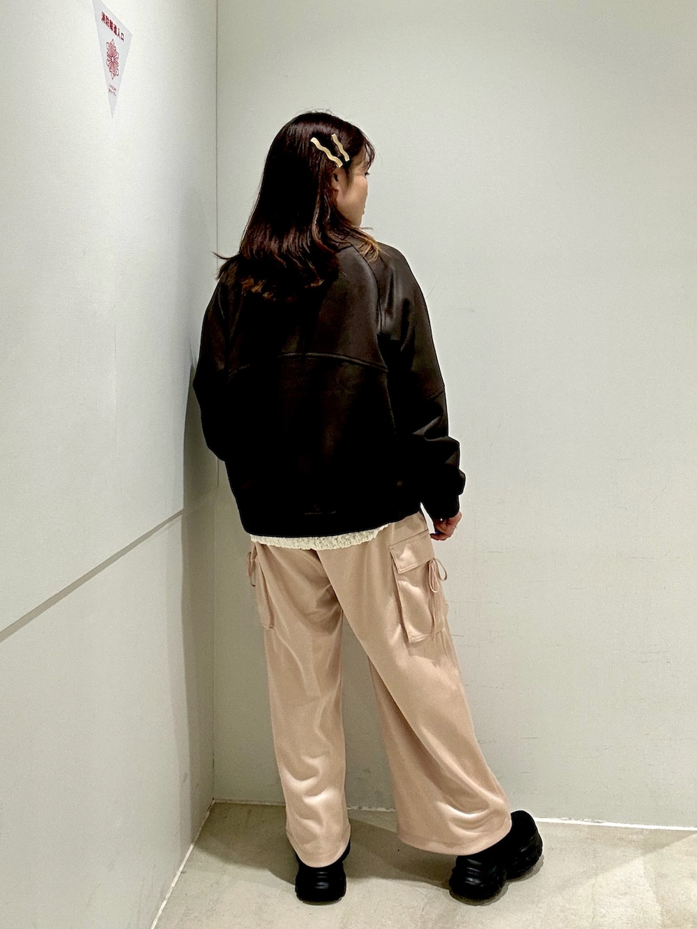 ピンク系のカーゴパンツ、ブラウン系のブルゾン、ホワイト系のニット/セーターを着用したレディースの秋コーディネートの3枚目の写真