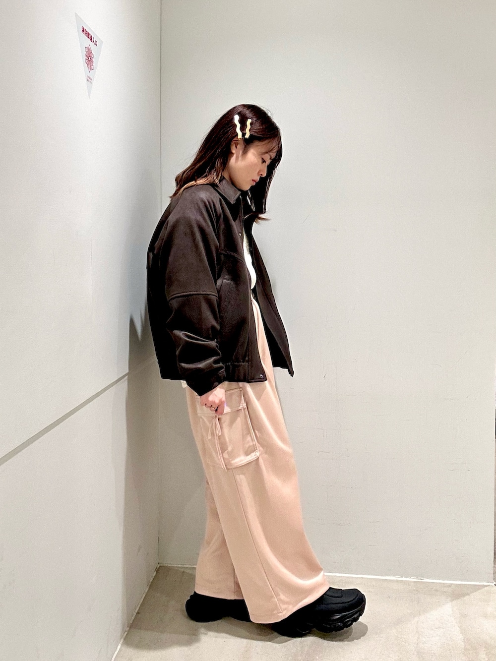 ピンク系のカーゴパンツ、ブラウン系のブルゾン、ホワイト系のニット/セーターを着用したレディースの秋コーディネートの2枚目の写真