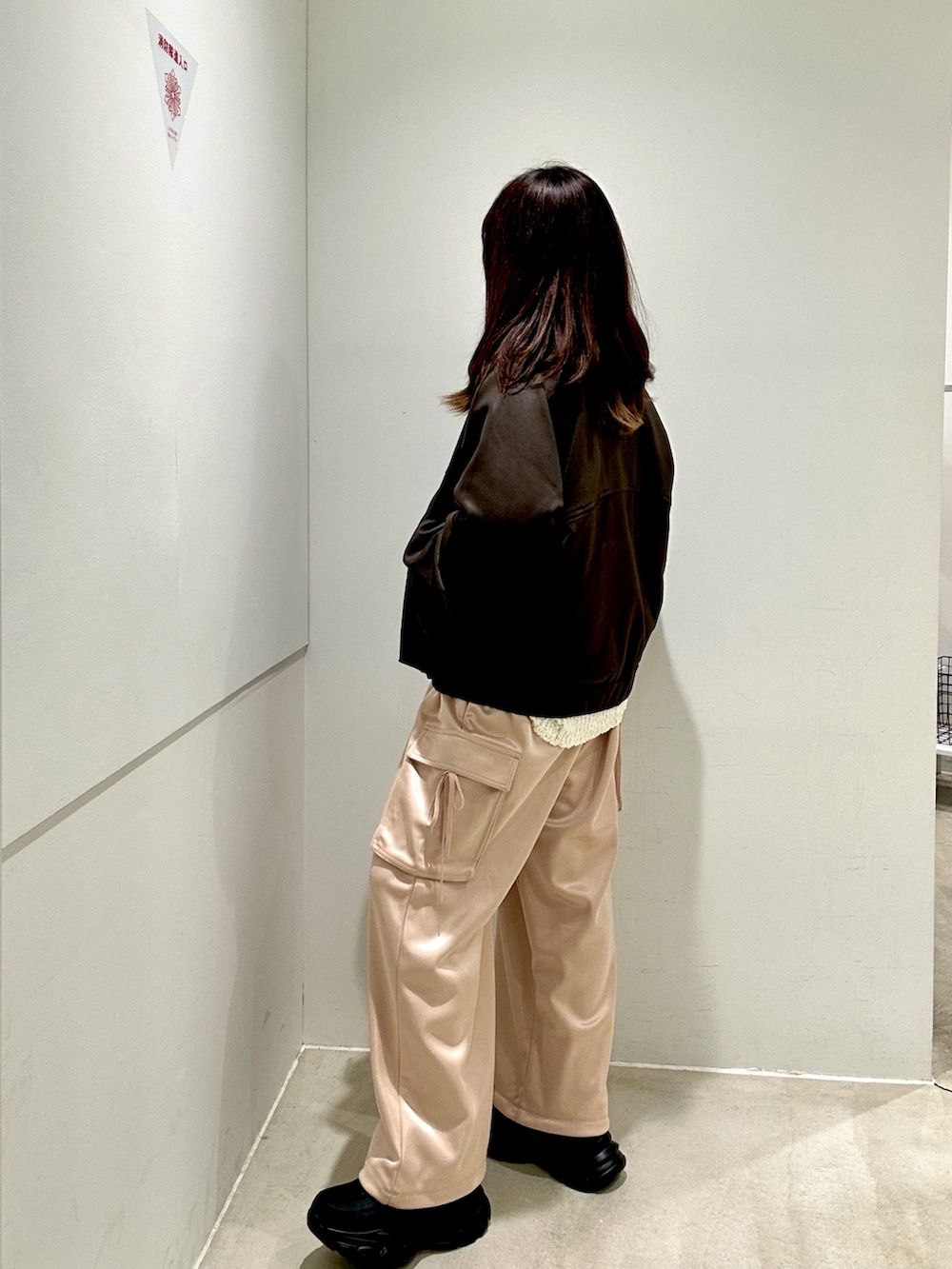 ピンク系のカーゴパンツ、ブラウン系のブルゾン、ホワイト系のニット/セーターを着用したレディースの秋コーディネートの4枚目の写真