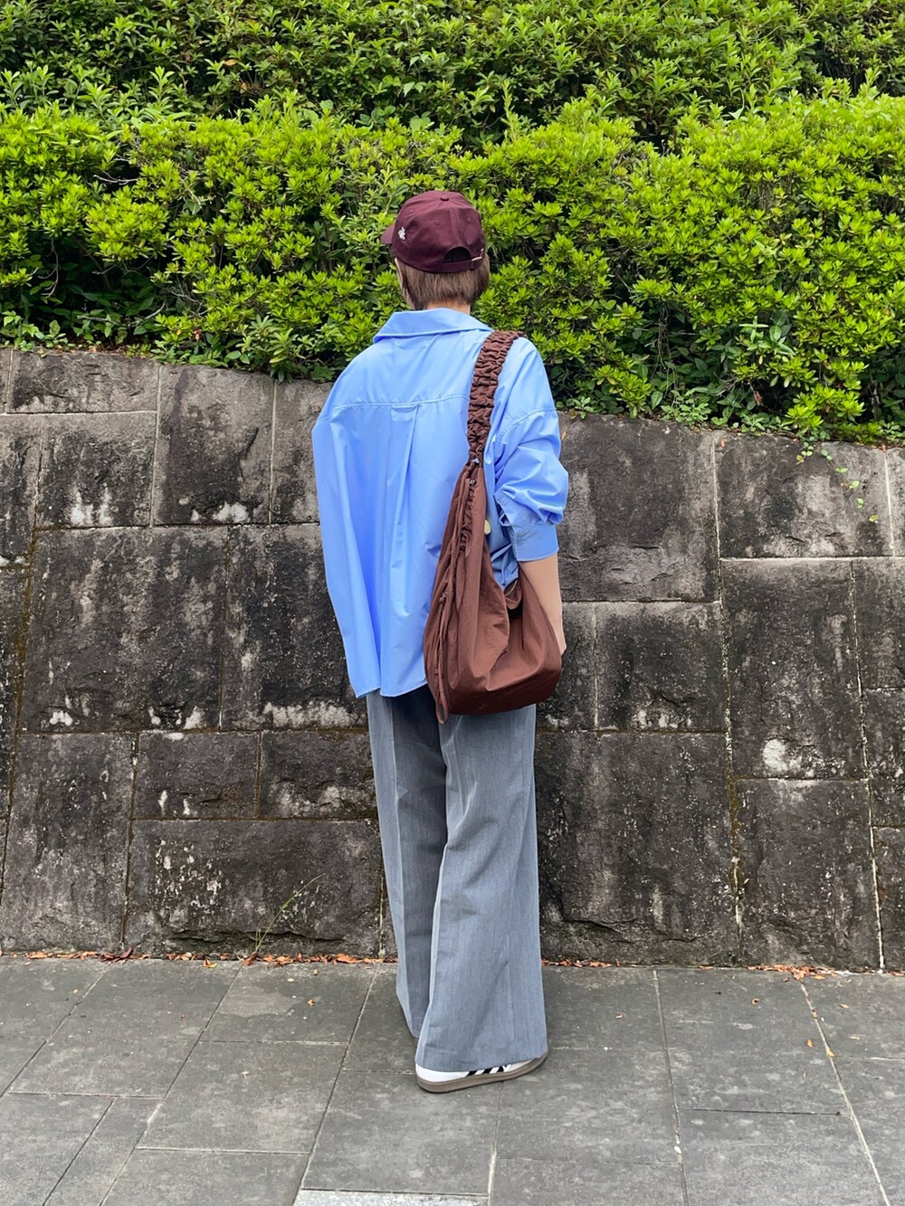 ホワイト系のTシャツ/カットソー、ブラウン系のショルダーバッグ、ホワイト系のスニーカーを着用したレディースの秋コーディネートの4枚目の写真