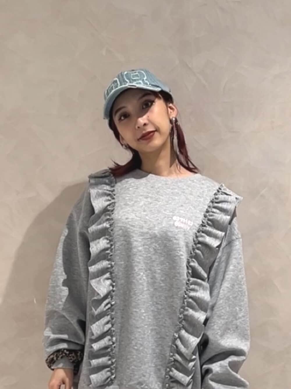 ブラック系のブーツ、グレー系のスウェット、ブルー系のキャップを着用したレディースの秋コーディネートの5枚目の写真