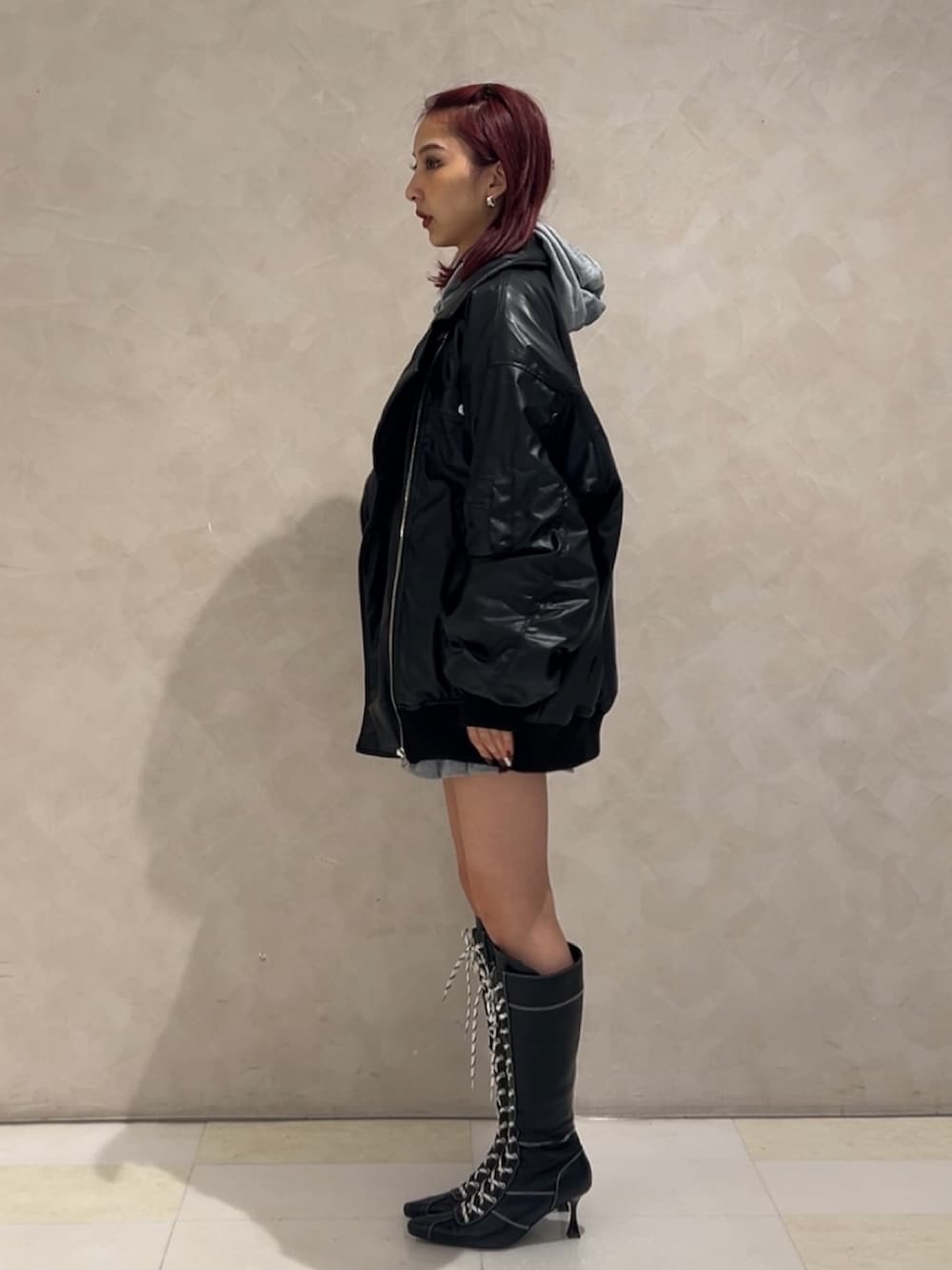 ブラック系のMA-1、グレー系のパーカー、グレー系のスカートを着用したレディースの秋コーディネートの4枚目の写真