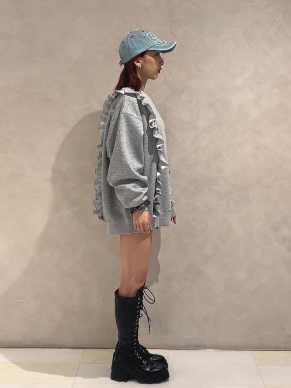 ブラック系のブーツ、グレー系のスウェット、ブルー系のキャップを着用したレディースの秋コーディネートの4枚目の写真