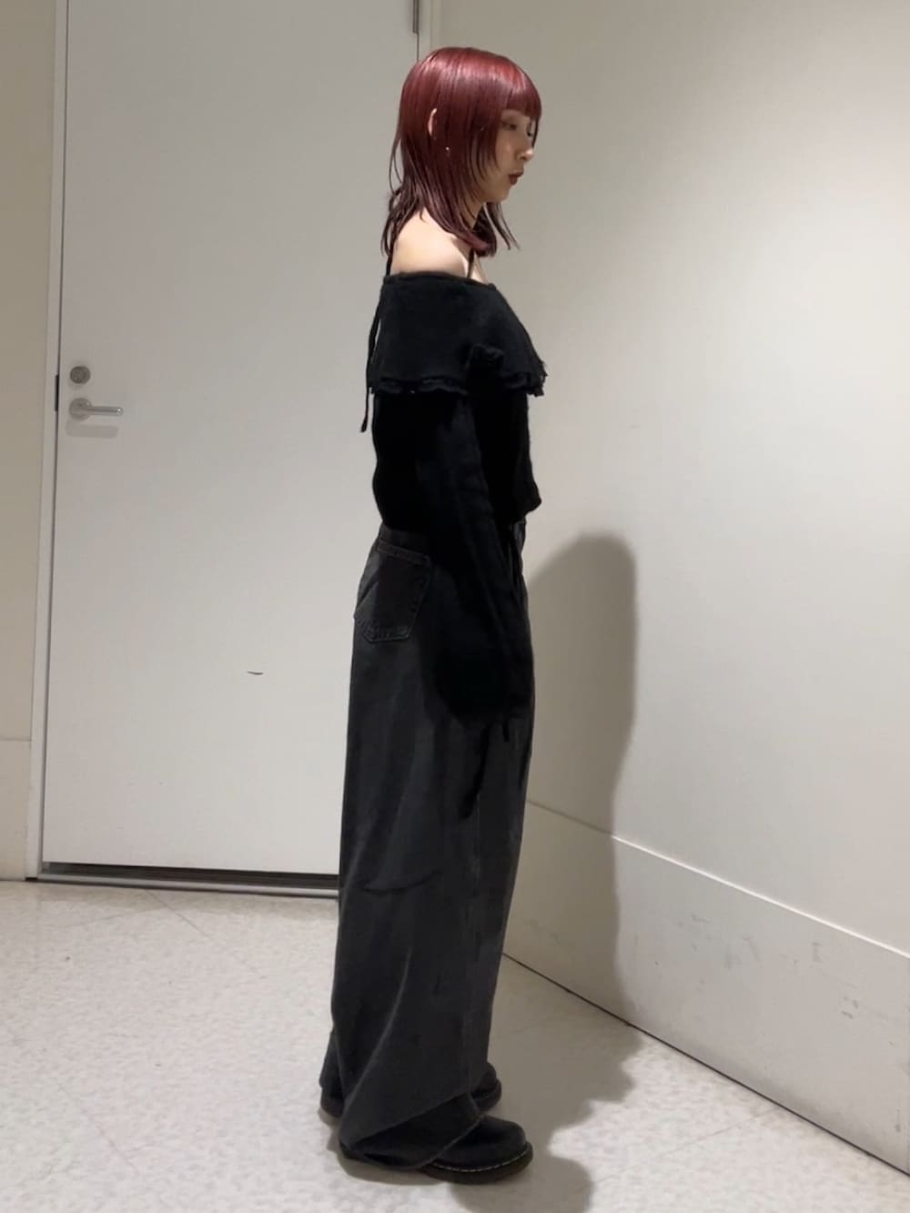 ブラック系のニット/セーター、ブラック系のデニムパンツを着用したレディースの冬コーディネートの2枚目の写真