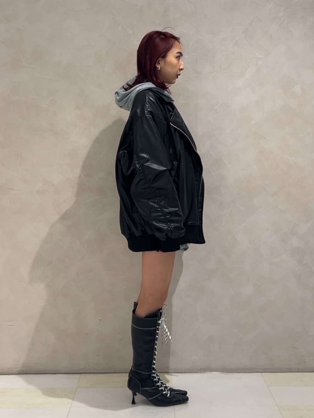 ブラック系のMA-1、グレー系のパーカー、グレー系のスカートを着用したレディースの秋コーディネートの2枚目の写真