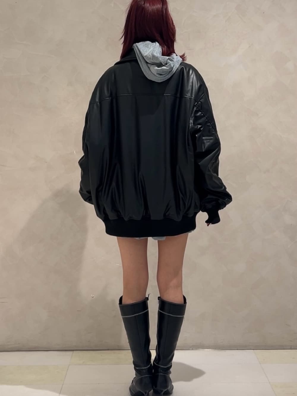 ブラック系のMA-1、グレー系のパーカー、グレー系のスカートを着用したレディースの秋コーディネートの3枚目の写真