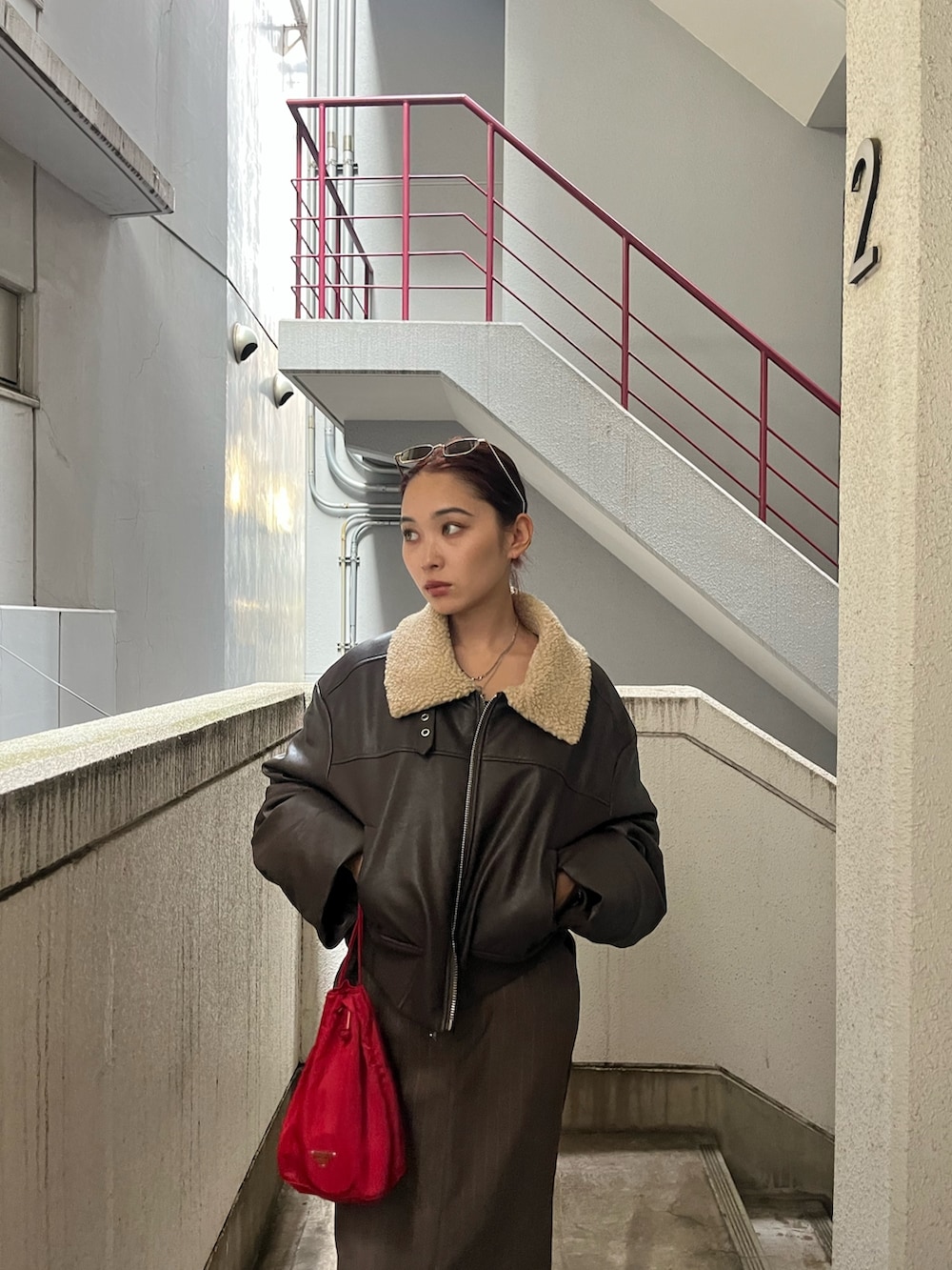 ブラウン系のブルゾン、ブラウン系のスカート、ブラック系のブーツを着用したレディースの秋コーディネートの4枚目の写真