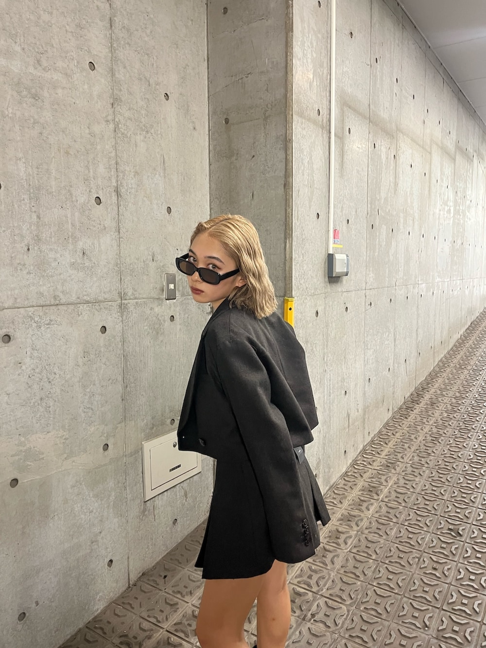 ブラウン系のテーラードジャケット、ブラウン系のスカート、ブラック系のブーツを着用したレディースの夏コーディネートの3枚目の写真