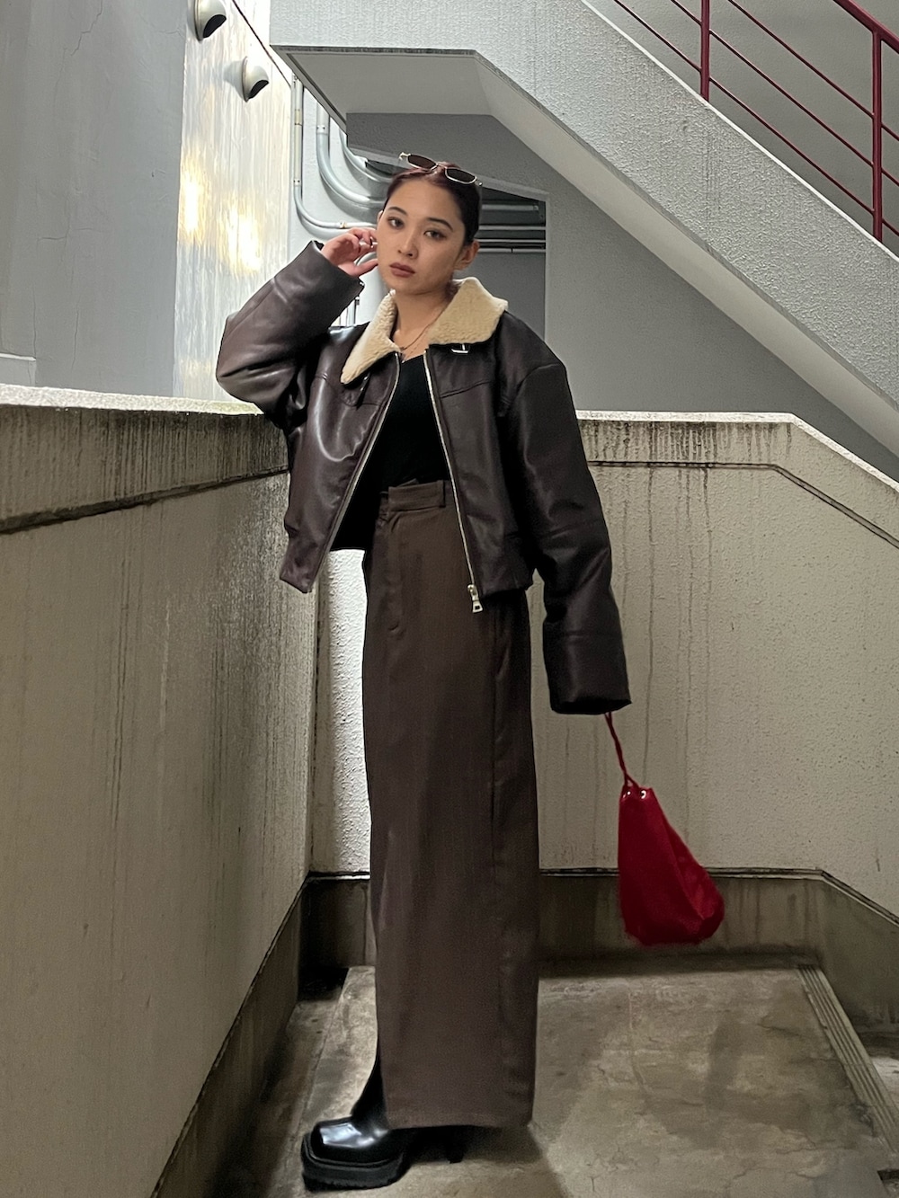 ブラウン系のブルゾン、ブラウン系のスカート、ブラック系のブーツを着用したレディースの秋コーディネートの2枚目の写真