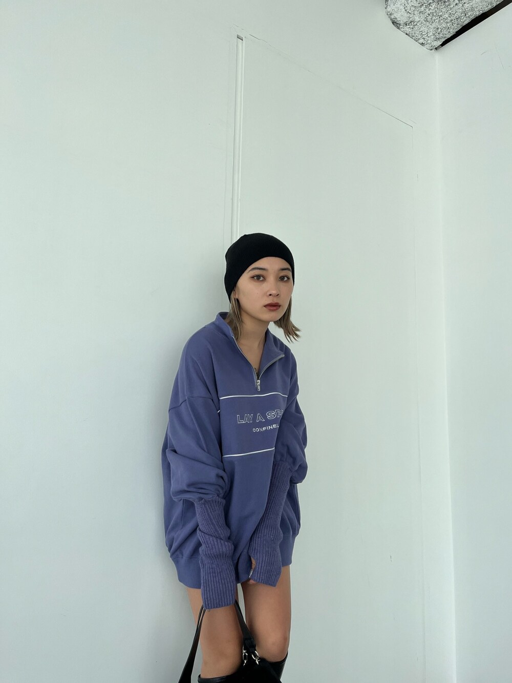 パープル系のスウェット、ブラック系のブーツ、ブラック系のハンドバッグを着用したレディースの秋コーディネートの4枚目の写真