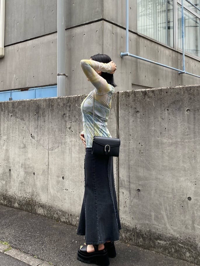 イエロー系のシャツ/ブラウス、ブラック系のスカート、ブラック系のサンダルを着用したレディースの春コーディネートの3枚目の写真