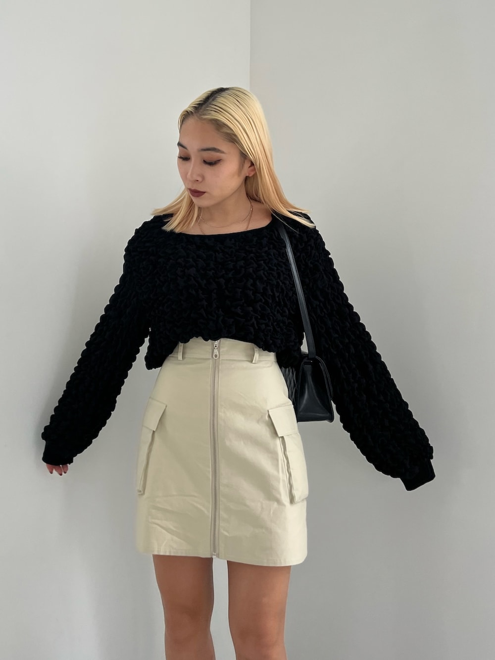 ブラック系のTシャツ/カットソー、グリーン系のスカート、ブラック系のブーツを着用したレディースの冬コーディネートの2枚目の写真