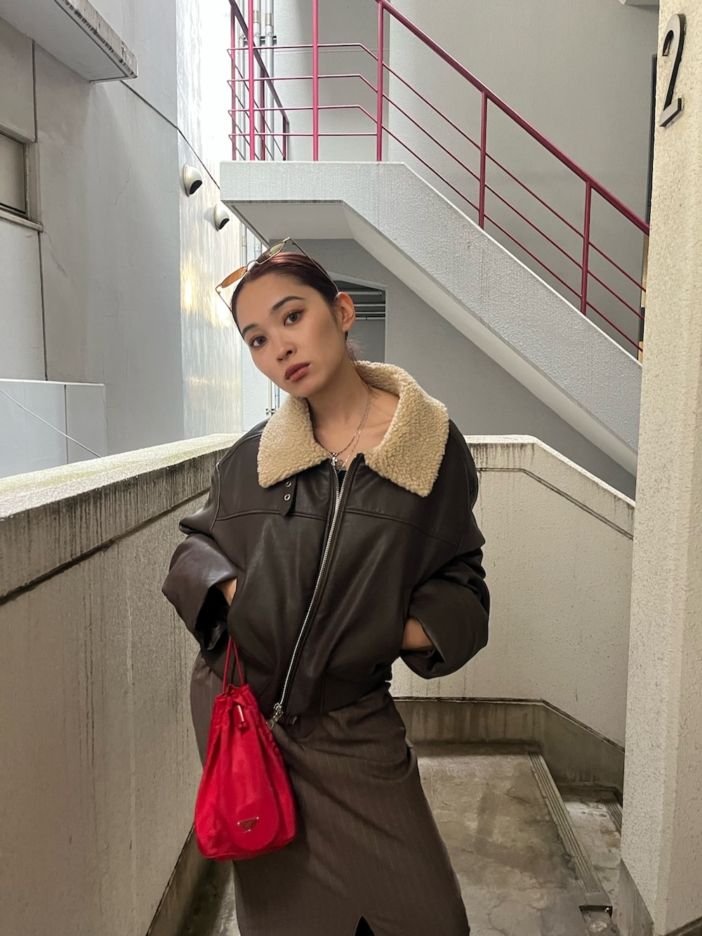 ブラウン系のブルゾン、ブラウン系のスカート、ブラック系のブーツを着用したレディースの秋コーディネートの3枚目の写真