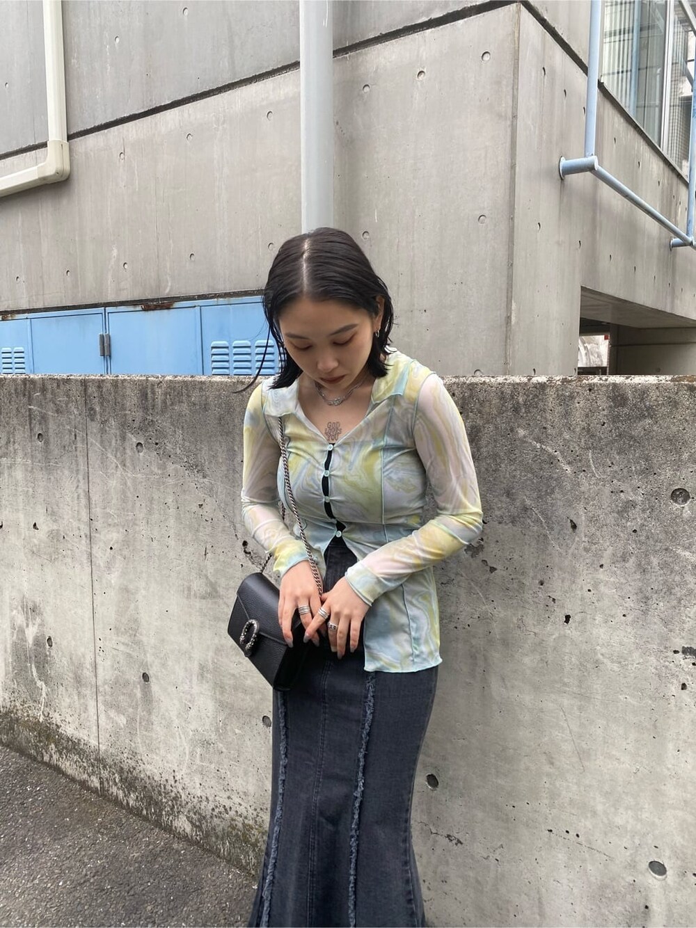 イエロー系のシャツ/ブラウス、ブラック系のスカート、ブラック系のサンダルを着用したレディースの春コーディネートの2枚目の写真