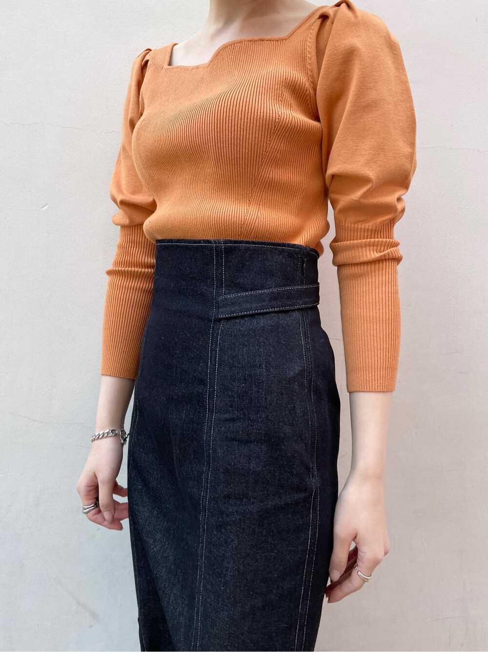 ブラック系のその他シューズ、オレンジ系のニット/セーター、ブラック系のスカートを着用したレディースの冬コーディネートの7枚目の写真