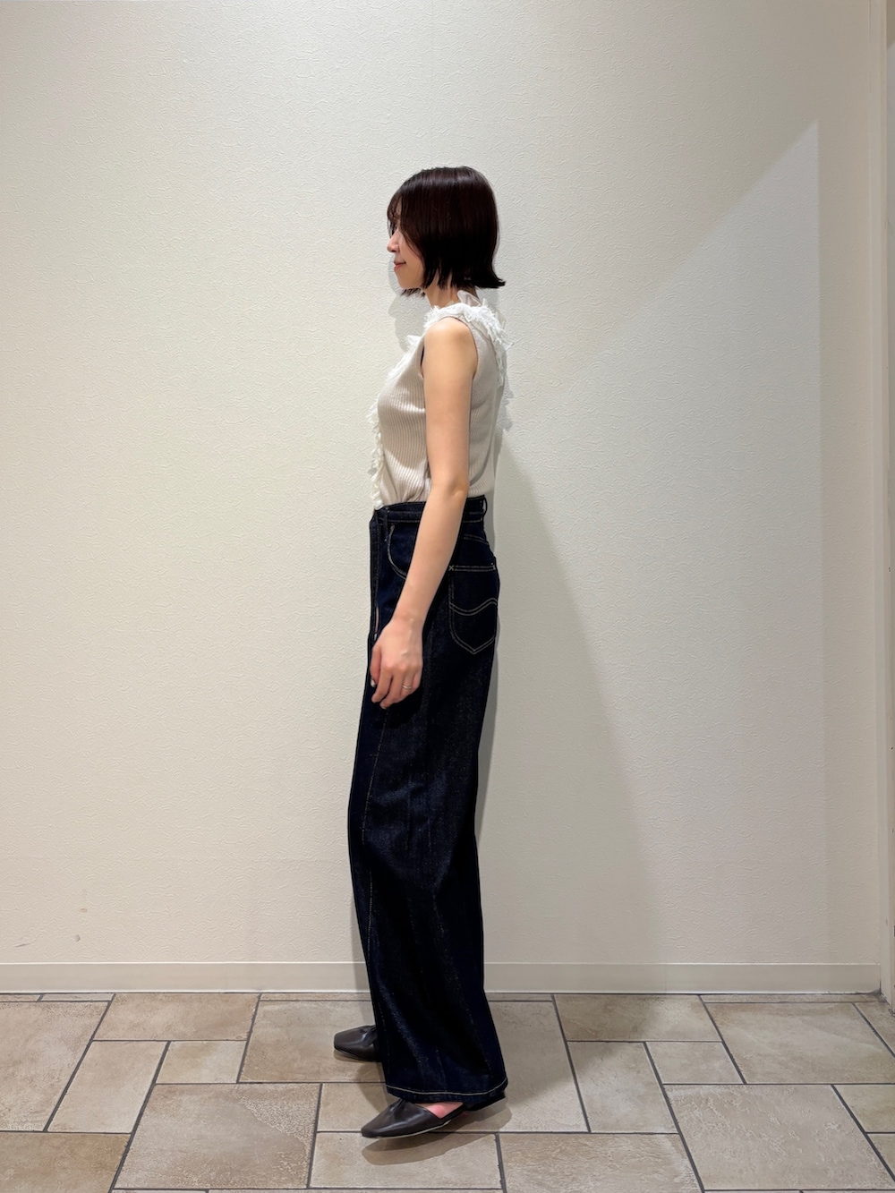 ベージュ系のニット/セーター、ブルー系のデニムパンツ、ブラウン系のサンダルを着用したレディースの夏コーディネートの2枚目の写真