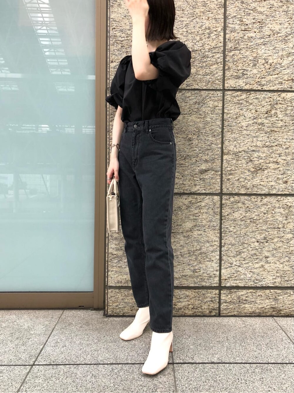 ブラック系のシャツ/ブラウス、ブラック系のデニムジャケット、ホワイト系のその他シューズを着用したレディースの夏コーディネートの2枚目の写真