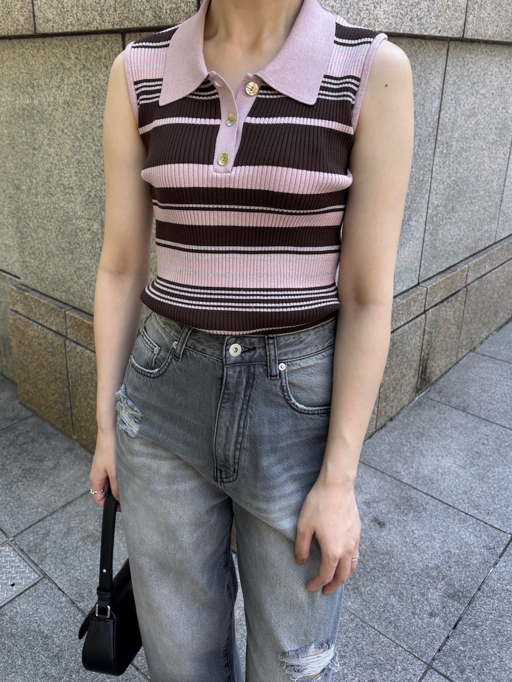 グレー系のデニムパンツ、ピンク系のニット/セーター、ホワイト系のサンダルを着用したレディースの春コーディネートの5枚目の写真