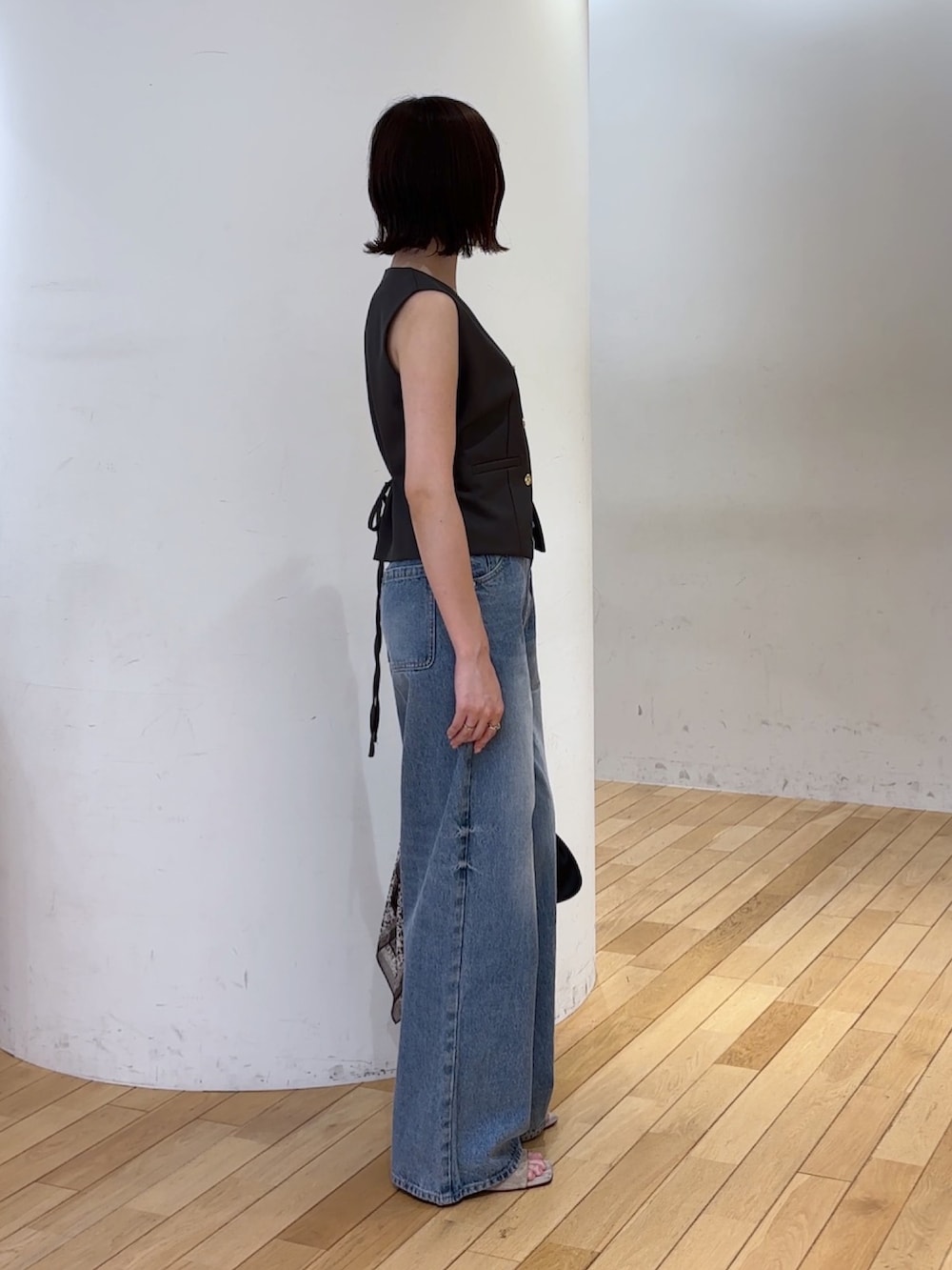 グレー系のワンピース、ブルー系のデニムパンツ、ブラック系のハンドバッグを着用したレディースの夏コーディネートの5枚目の写真