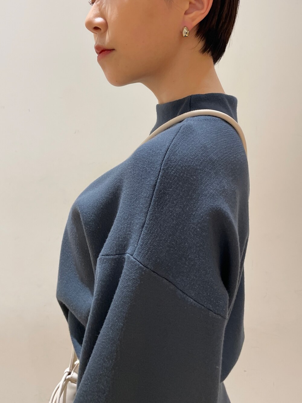 グリーン系のスカート、グリーン系のニット/セーター、ブラック系のブーツを着用したレディースの冬コーディネートの7枚目の写真