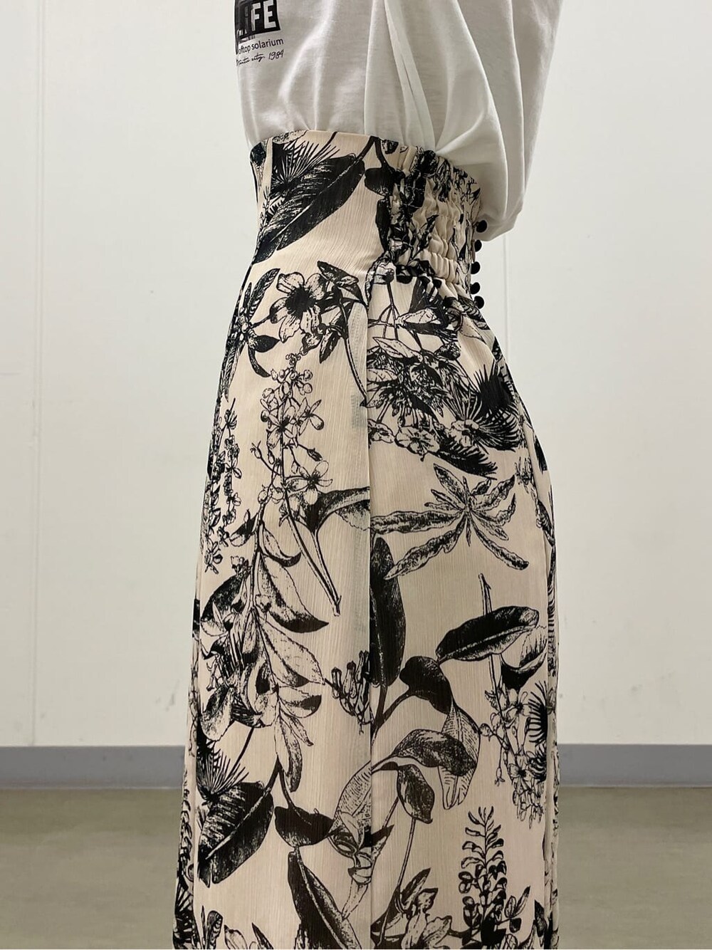 ベージュ系のスニーカー、ホワイト系のTシャツ/カットソー、ベージュ系のスカートを着用したレディースの夏コーディネートの7枚目の写真