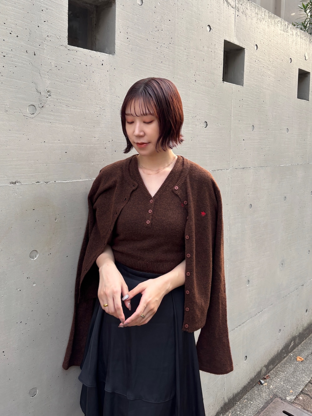 ブラック系のスカート、ブラウン系のアンサンブル、ブラック系のブーツを着用したレディースの秋コーディネートの5枚目の写真