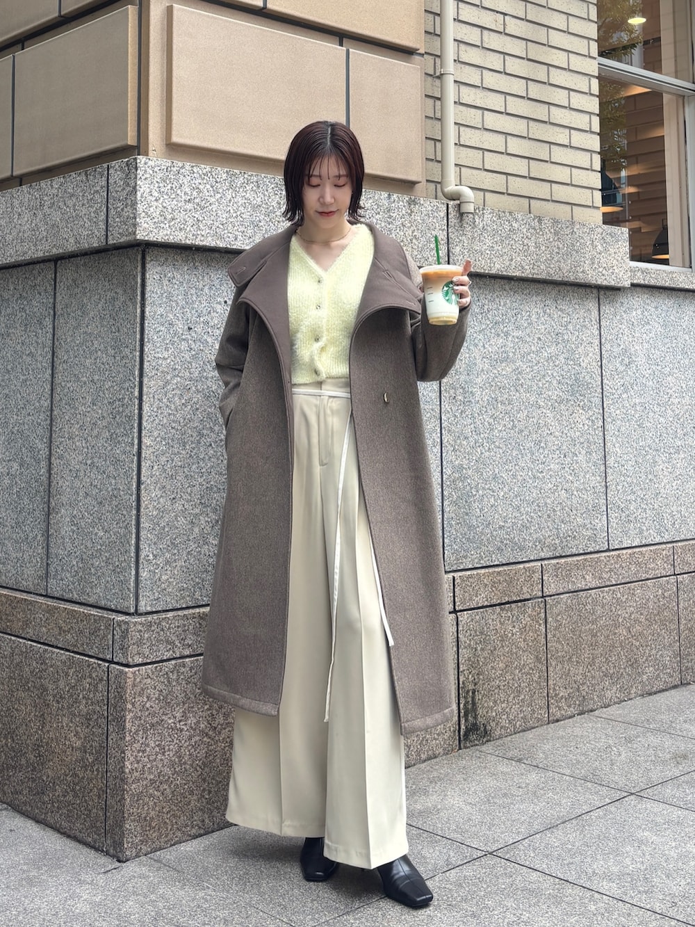 ベージュ系のその他パンツ、ブラウン系のチェスターコート、イエロー系のカーディガン/ボレロを着用したレディースの秋コーディネートの2枚目の写真