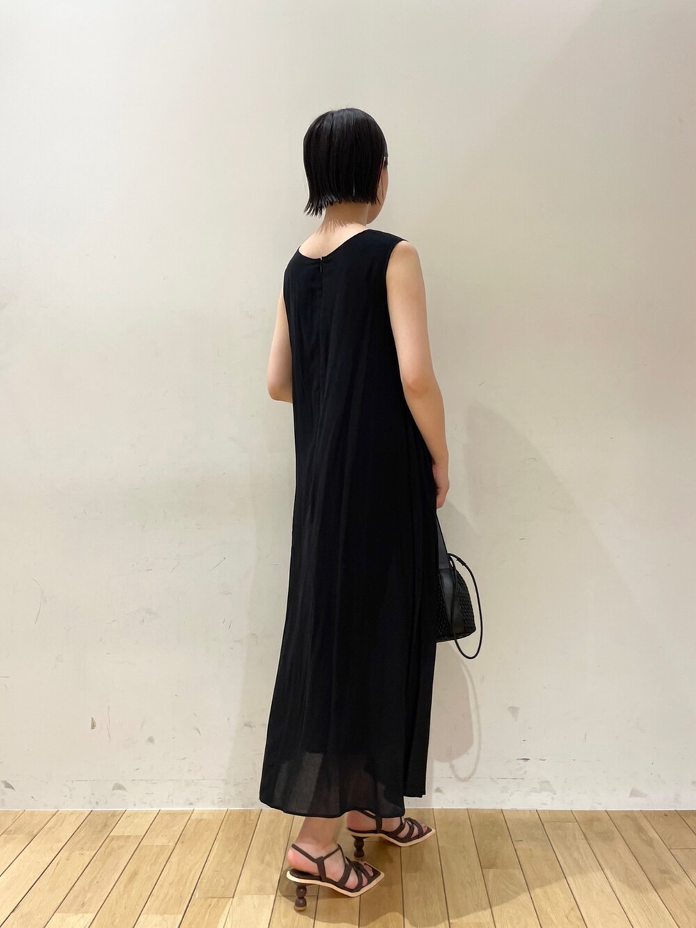 ブラック系のワンピース、ブラック系のハンドバッグ、ブラウン系のサンダルを着用したレディースの夏コーディネートの7枚目の写真