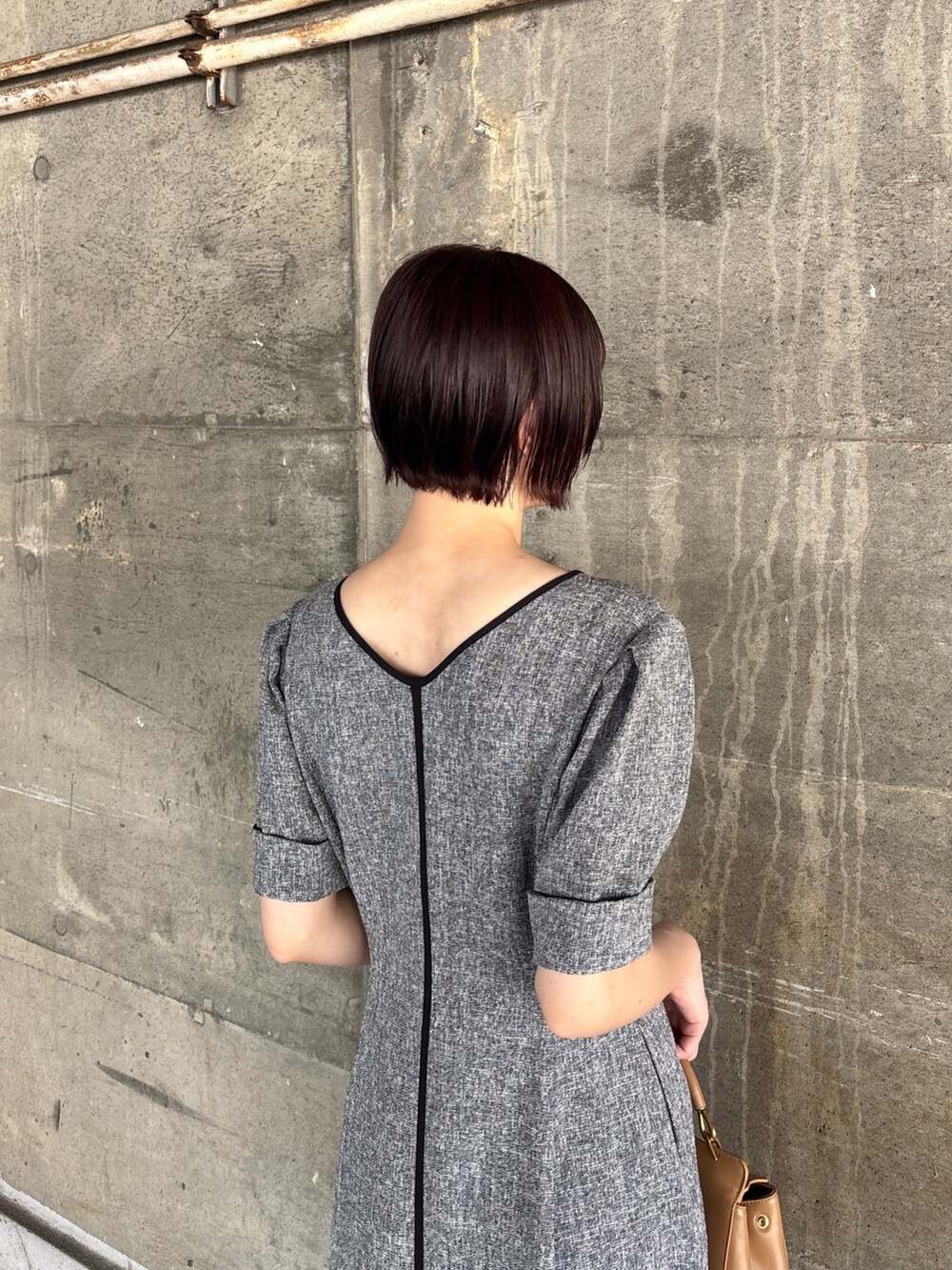 ブラック系のワンピース、イエロー系のハンドバッグ、ブラック系のサンダルを着用したレディースの夏コーディネートの6枚目の写真