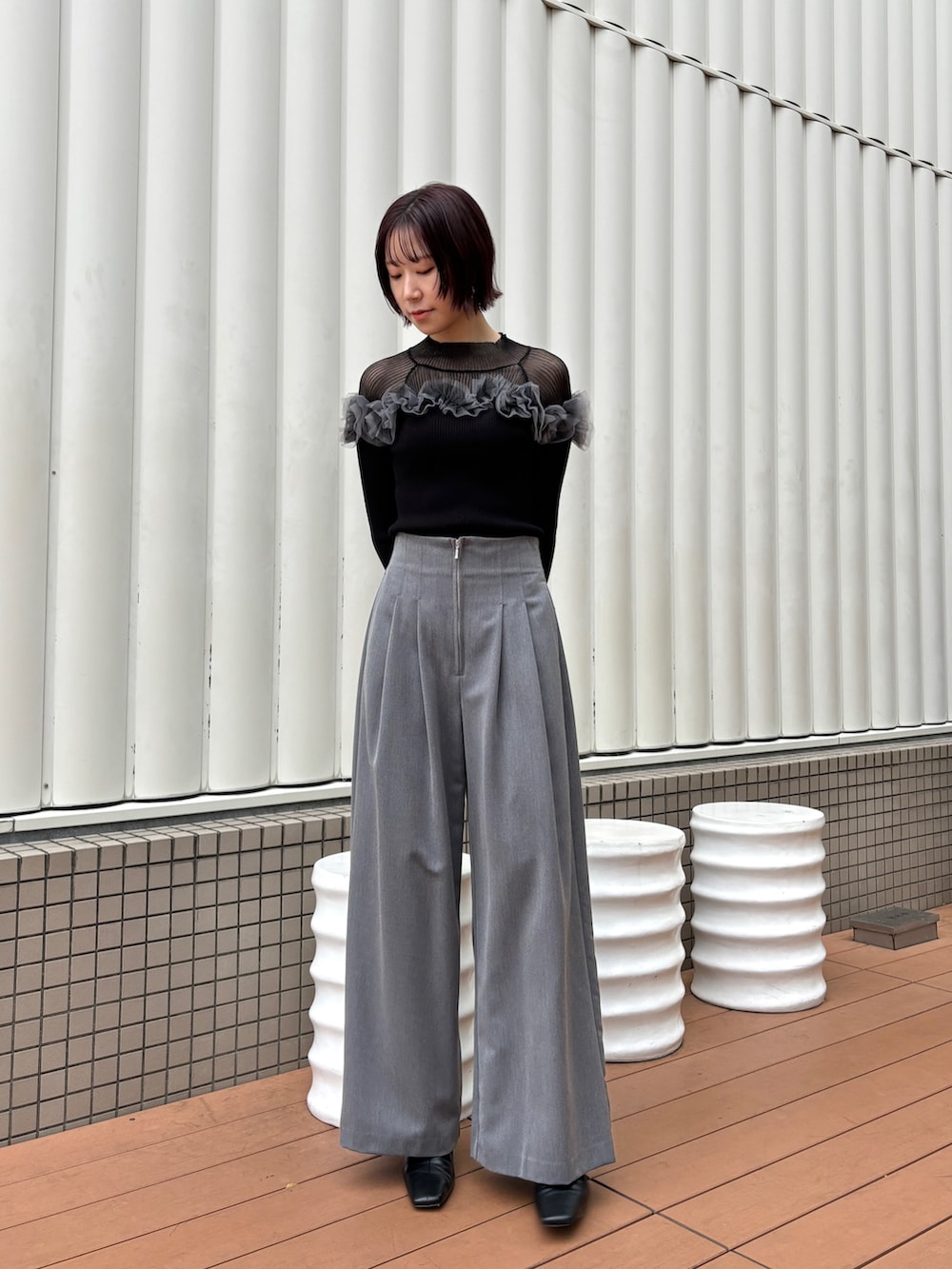グレー系のその他パンツ、ブラック系のニット/セーター、ブラック系のブーツを着用したレディースの秋コーディネートの4枚目の写真