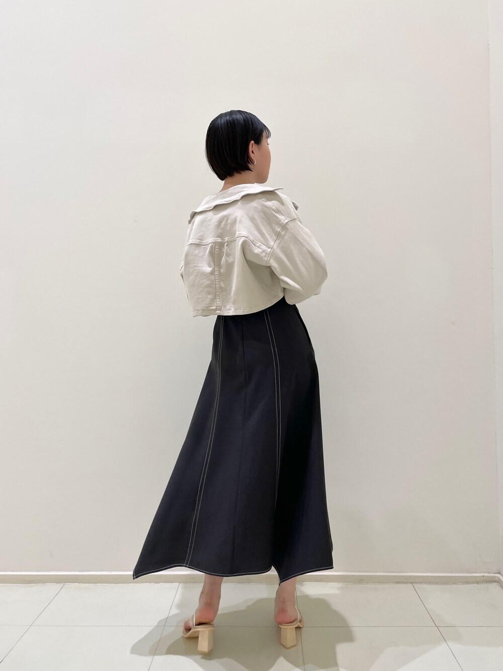 ブラック系のワンピース、その他のサンダル、ベージュ系のテーラードジャケットを着用したレディースの春コーディネートの3枚目の写真