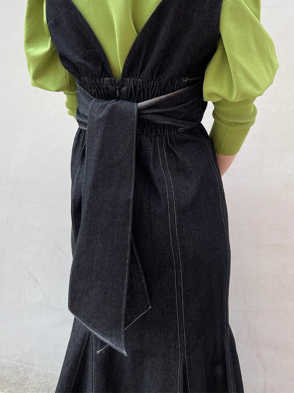 ブラック系のワンピース、グリーン系のニット/セーター、ブラック系のサンダルを着用したレディースの春コーディネートの8枚目の写真