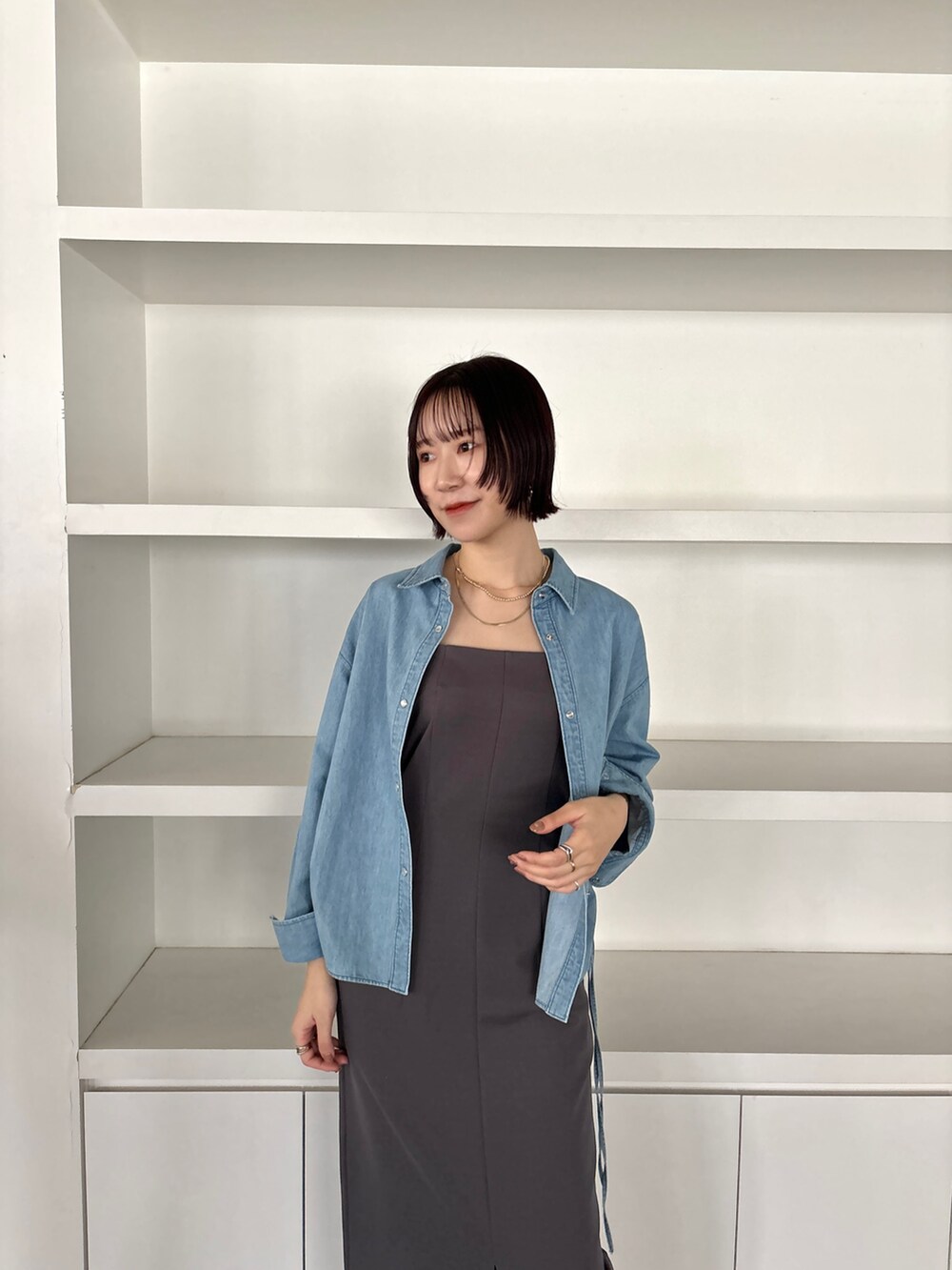 グレー系のワンピース、ホワイト系のサンダル、ブルー系のシャツ/ブラウスを着用したレディースの冬コーディネートの5枚目の写真