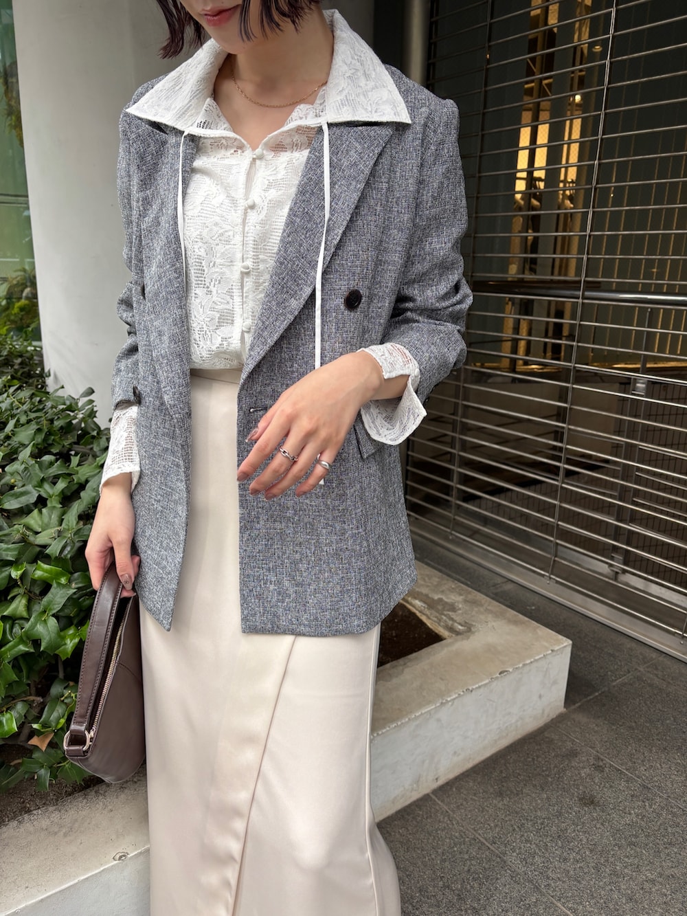 ホワイト系のスカート、ブラック系のテーラードジャケット、シルバー系のパンプスを着用したレディースの冬コーディネートの7枚目の写真