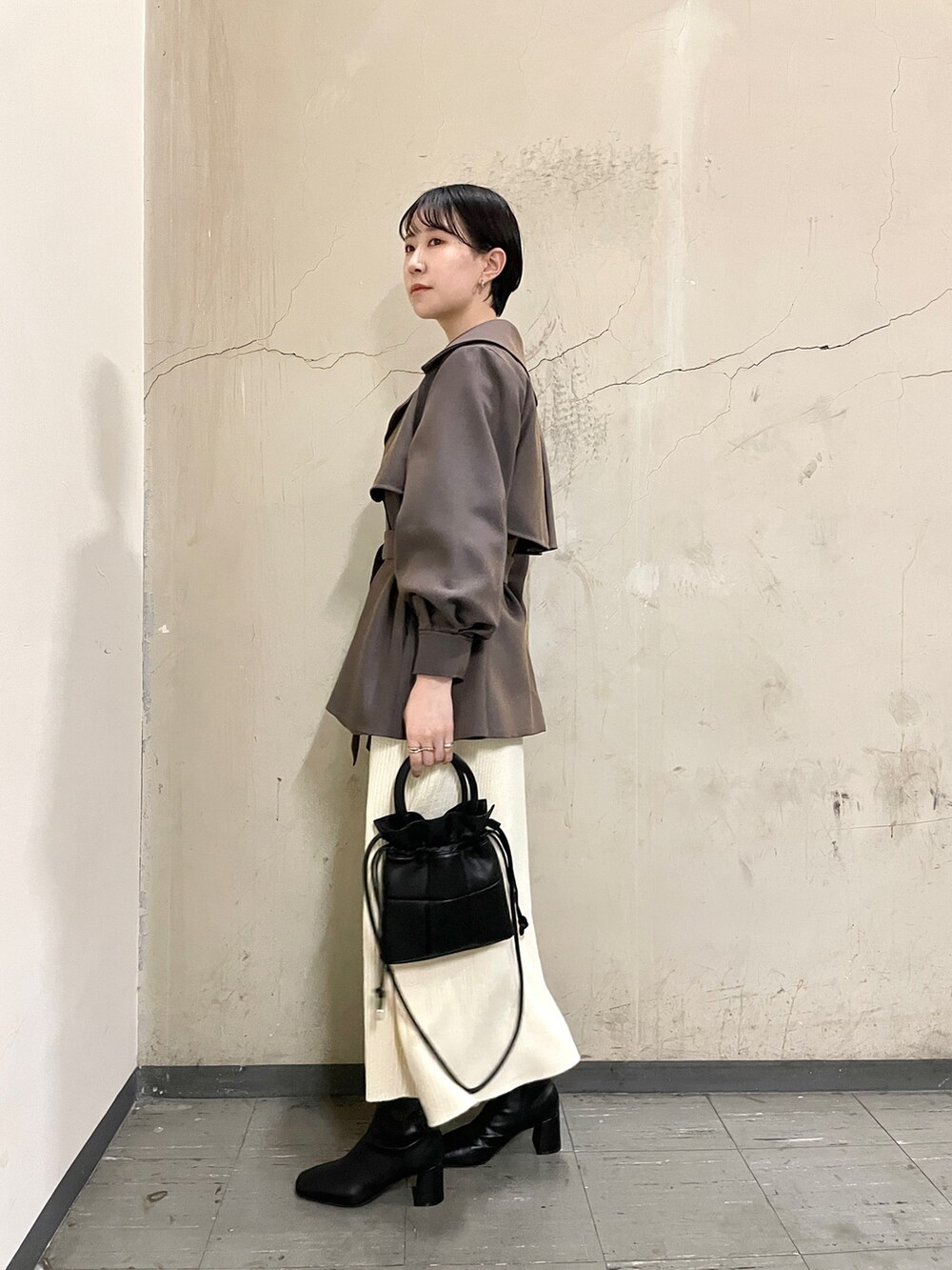 ブラック系のブーツ、ブラック系のハンドバッグ、ブラウン系のその他アウターを着用したレディースの秋コーディネートの2枚目の写真