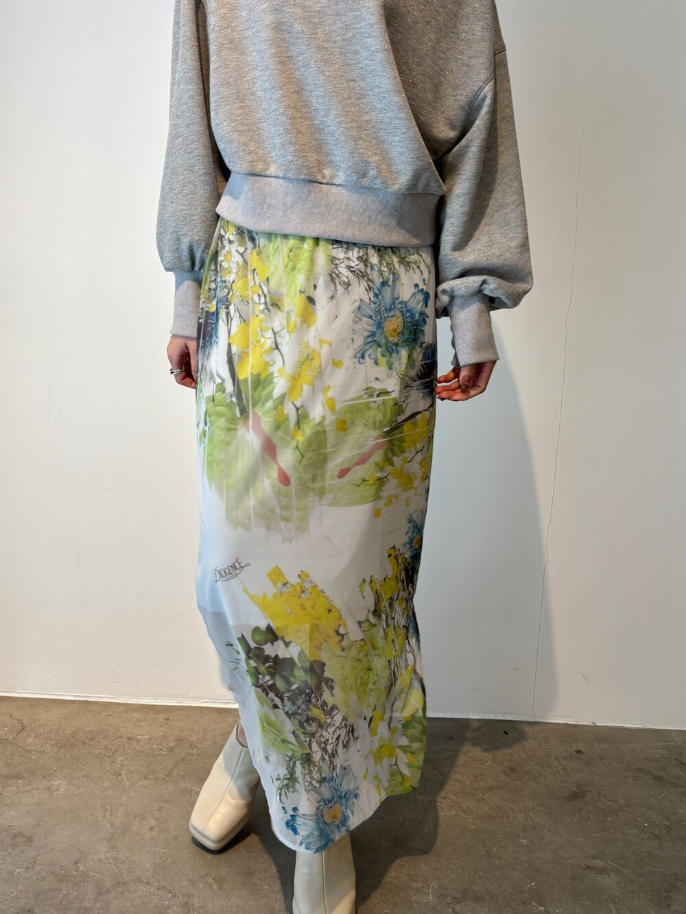 グレー系のスカート、グレー系のスウェット、ホワイト系のサンダルを着用したレディースの冬コーディネートの5枚目の写真