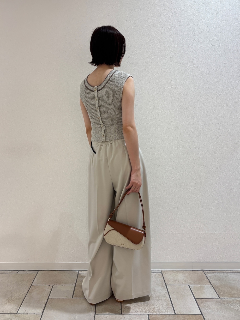 ホワイト系のその他パンツ、ホワイト系のサンダル、ブラウン系のハンドバッグを着用したレディースの夏コーディネートの3枚目の写真