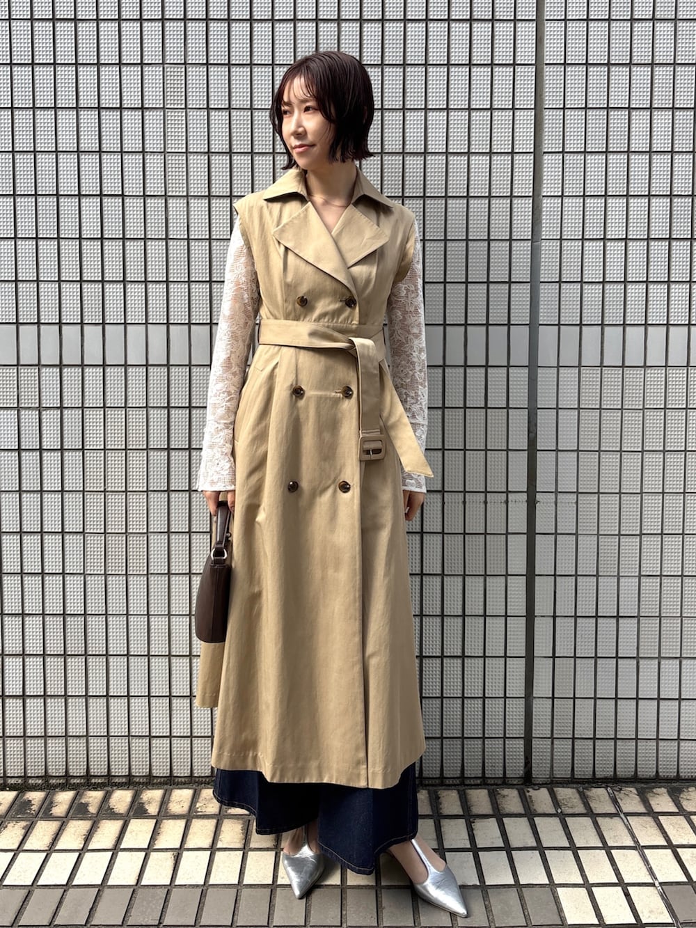 ブルー系のデニムパンツ、ベージュ系のトレンチコート、ホワイト系のシャツ/ブラウスを着用したレディースの冬コーディネートの7枚目の写真