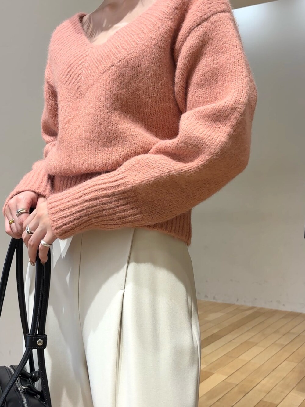 ピンク系のニット/セーター、ブラック系のショルダーバッグ、ホワイト系のその他パンツを着用したレディースの冬コーディネートの6枚目の写真