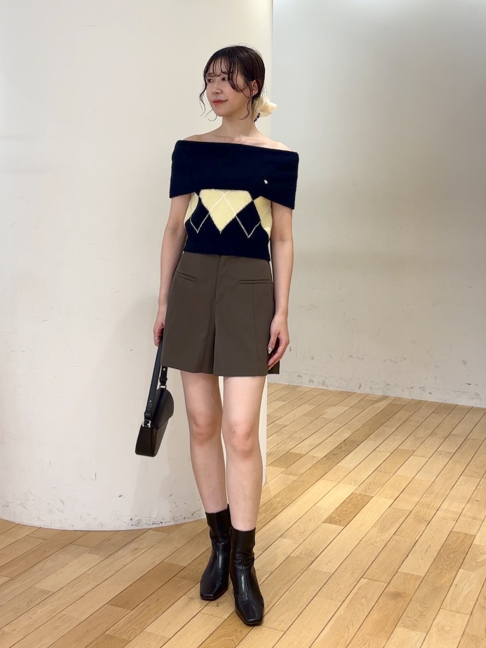 ブラウン系のその他パンツ、ブルー系のニット/セーター、ブラック系のハンドバッグを着用したレディースの夏コーディネートの5枚目の写真