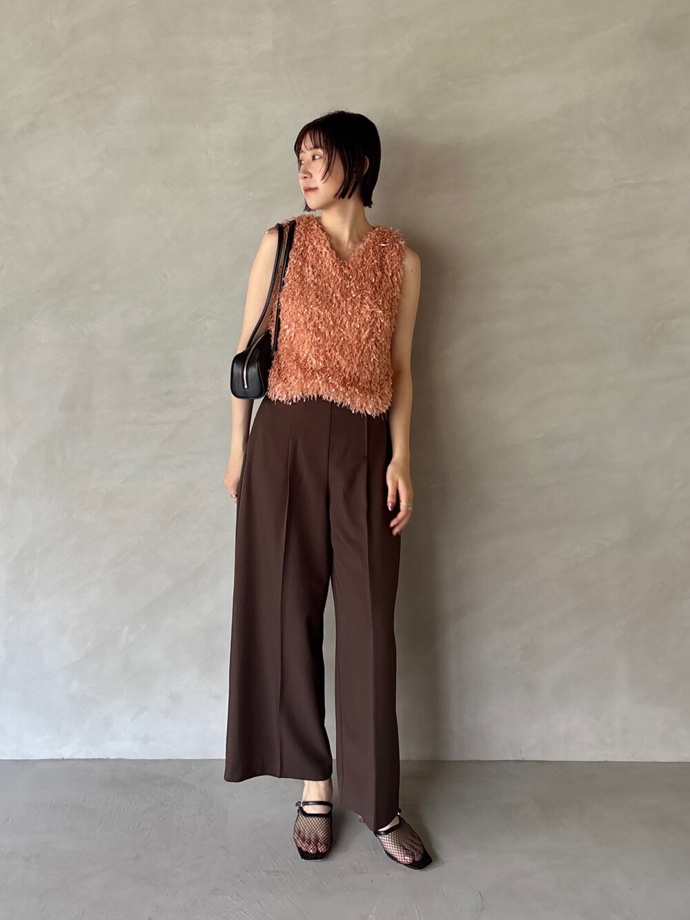 ブラウン系のその他パンツ、オレンジ系のTシャツ/カットソー、ブラック系のサンダルを着用したレディースの夏コーディネートの3枚目の写真