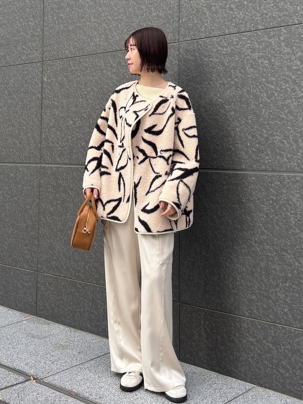 ホワイト系のカーゴパンツ、ホワイト系のニット/セーター、イエロー系のハンドバッグを着用したレディースの冬コーディネートの6枚目の写真