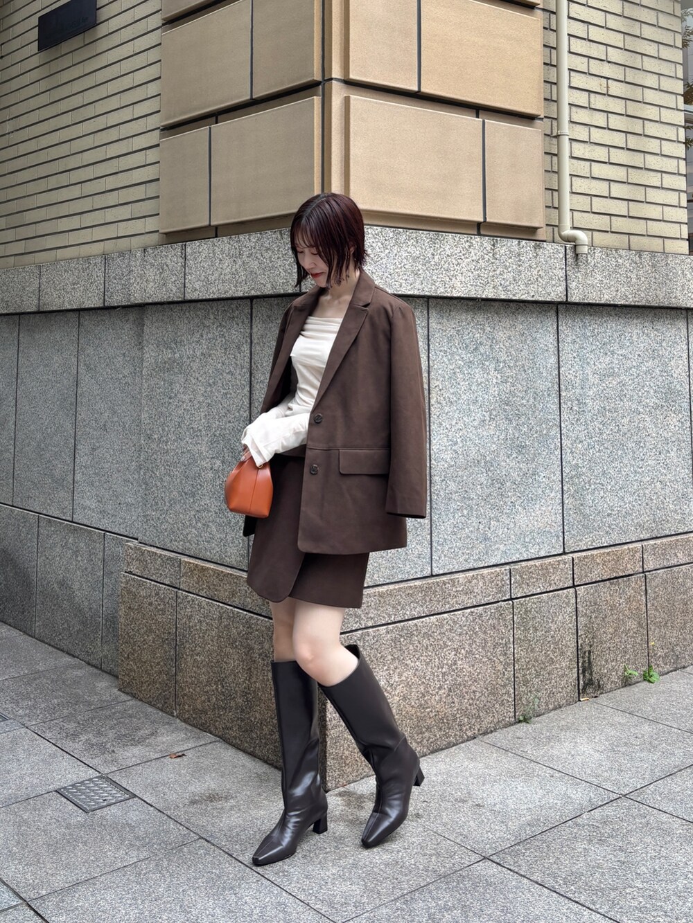 ブラウン系のブーツ、ブラウン系のハンドバッグ、ブラウン系のスカートを着用したレディースの秋コーディネートの4枚目の写真