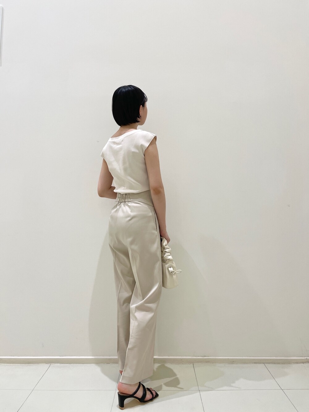 ブラック系のサンダル、ホワイト系のハンドバッグ、ホワイト系のその他パンツを着用したレディースの春コーディネートの5枚目の写真