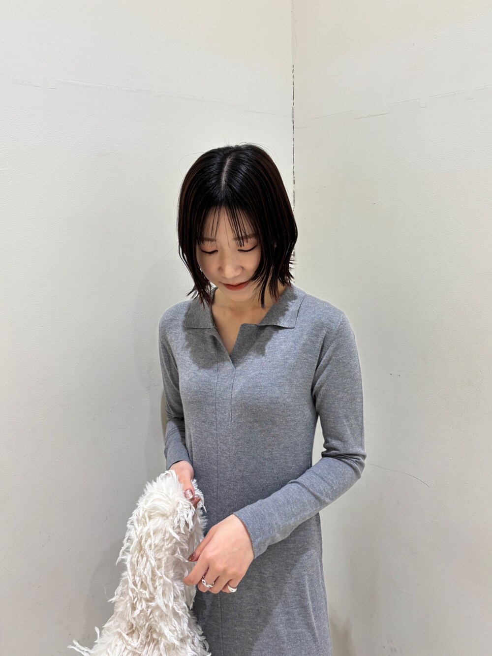 グレー系のワンピース、ホワイト系のハンドバッグを着用したレディースの冬コーディネートの7枚目の写真