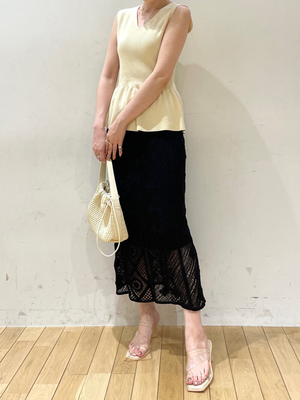 ベージュ系のハンドバッグ、ホワイト系のニット/セーター、ブラック系のスカートを着用したレディースの夏コーディネートの5枚目の写真